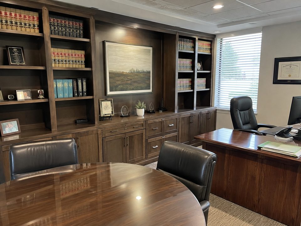 Law office built-in cabinetry in walnut with lit book shelving, closed base storage, and a credenza
